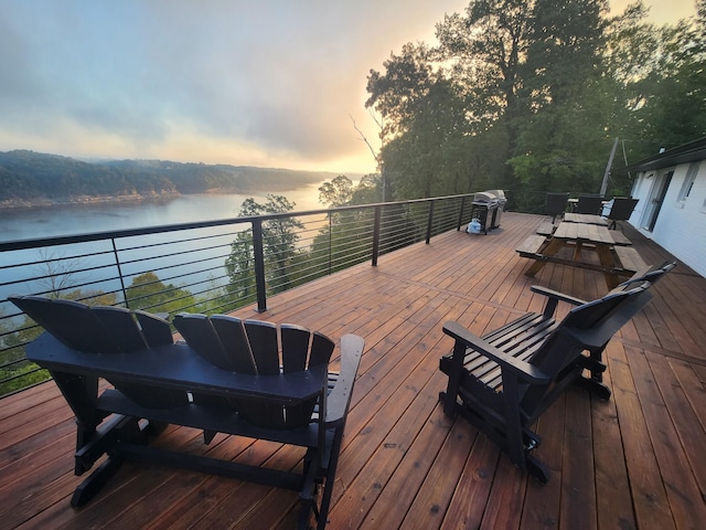 deck at dusk featuring a water view