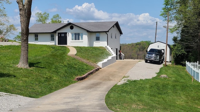 view of front facade with a front yard, a garage, and an outdoor structure