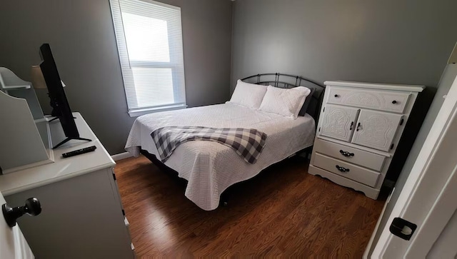 bedroom featuring dark hardwood / wood-style flooring and multiple windows