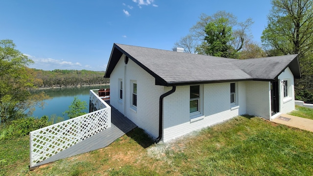 view of home's exterior featuring a water view and a yard