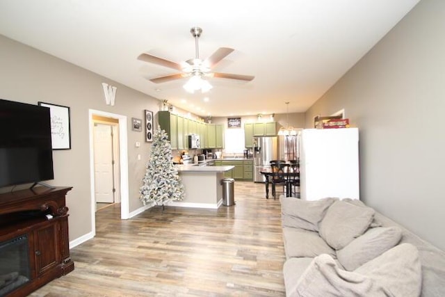 living room featuring ceiling fan and light hardwood / wood-style floors