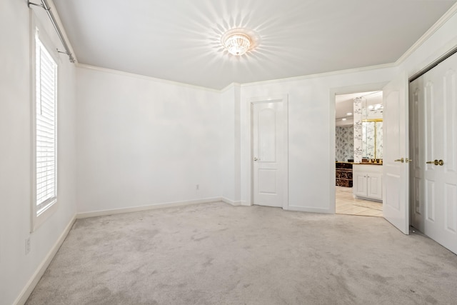 unfurnished bedroom with connected bathroom, light colored carpet, and multiple windows