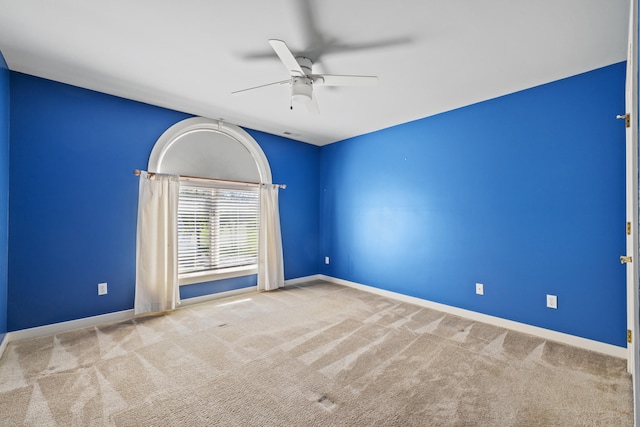 carpeted empty room featuring ceiling fan