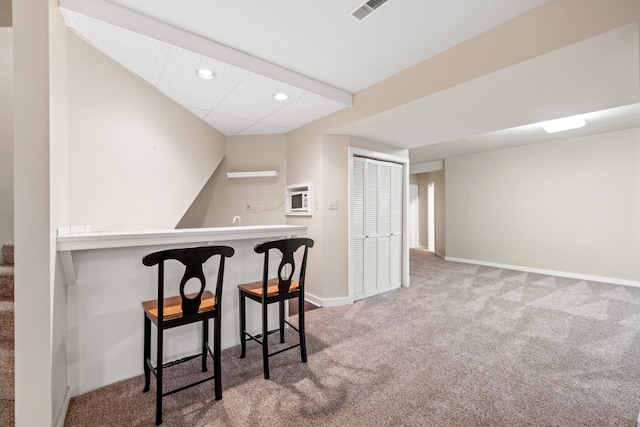 bar with carpet flooring and a drop ceiling