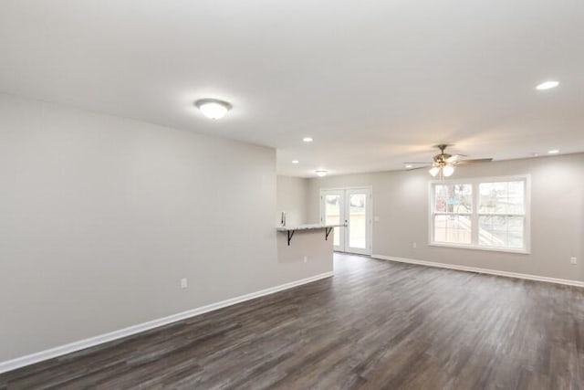 unfurnished living room featuring ceiling fan, french doors, and dark wood-type flooring