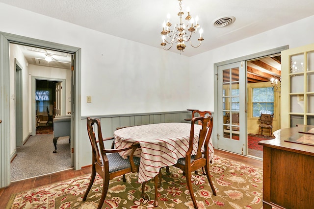 dining space featuring wood-type flooring, a textured ceiling, and a chandelier