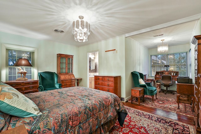 bedroom with crown molding, wood-type flooring, and a notable chandelier