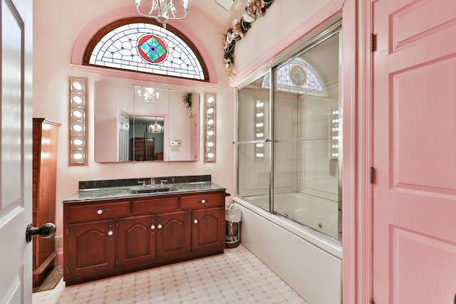 bathroom featuring an inviting chandelier, vanity, and enclosed tub / shower combo