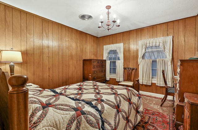 bedroom with a chandelier and wood walls