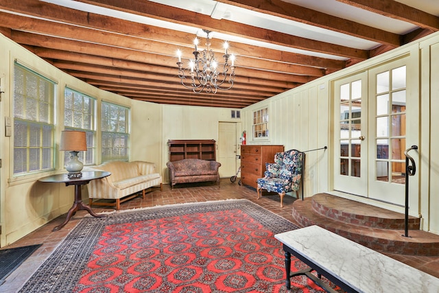 sitting room with an inviting chandelier and beamed ceiling