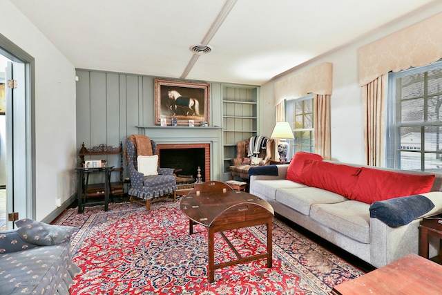 living room with built in shelves and a fireplace