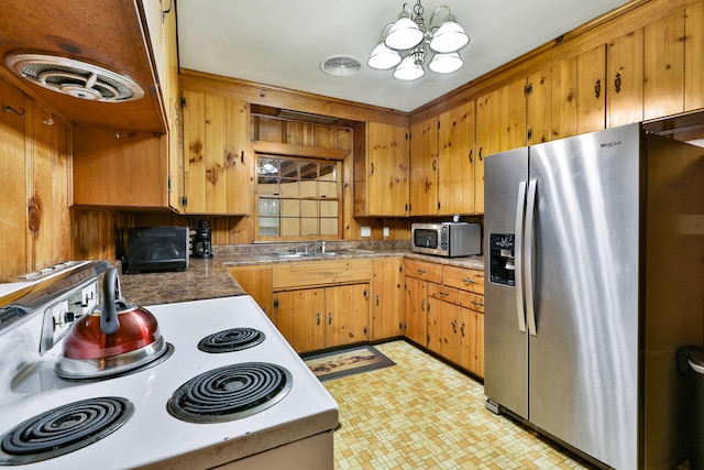 kitchen featuring appliances with stainless steel finishes, sink, and a chandelier