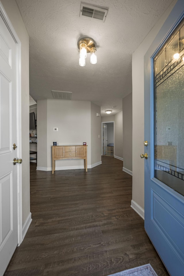 hallway featuring dark hardwood / wood-style flooring and a textured ceiling