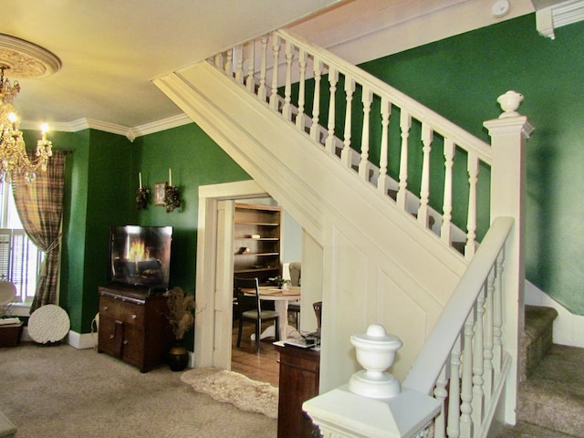 staircase with a notable chandelier, crown molding, and carpet flooring