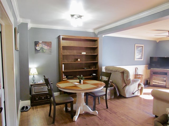 dining room with wood-type flooring, ornamental molding, and ceiling fan