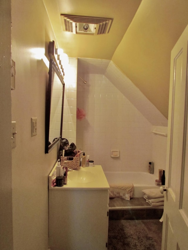 bathroom featuring vanity and tiled shower / bath