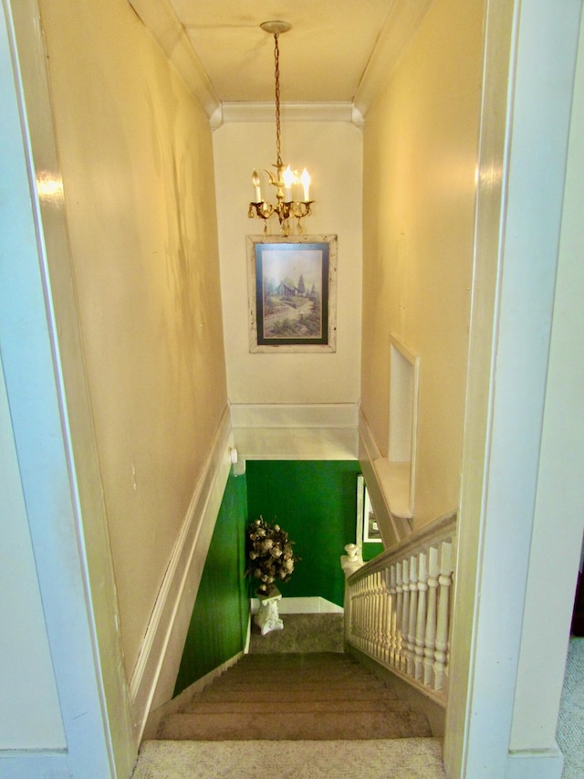 stairs with a notable chandelier and ornamental molding