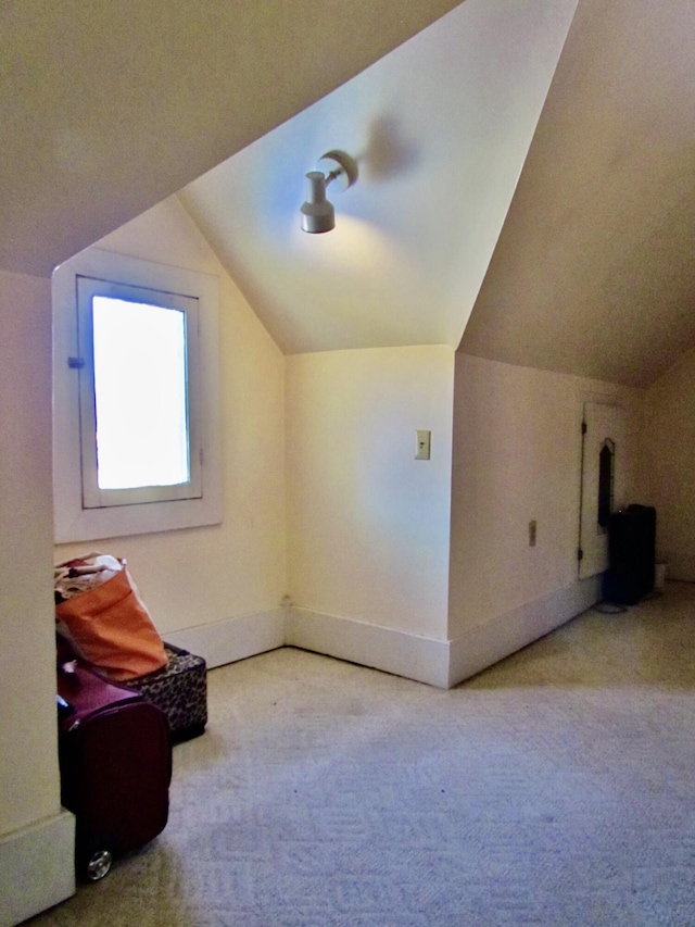 bonus room featuring light colored carpet and vaulted ceiling