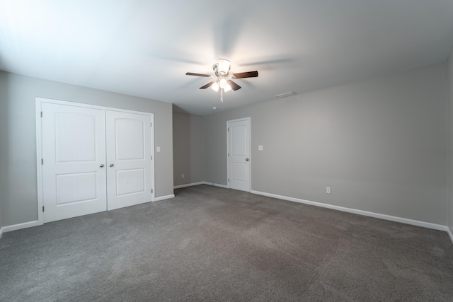 unfurnished bedroom with ceiling fan and dark carpet