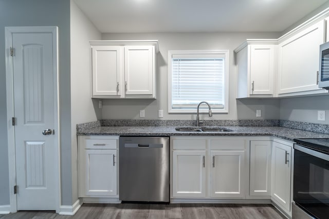 kitchen with stainless steel dishwasher, range with electric cooktop, white cabinetry, and sink