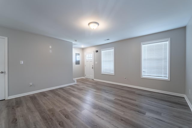 unfurnished room with electric panel and hardwood / wood-style flooring