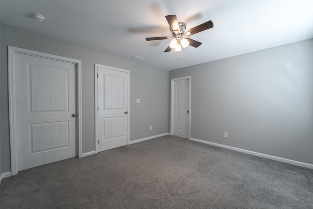 unfurnished bedroom with dark carpet and ceiling fan