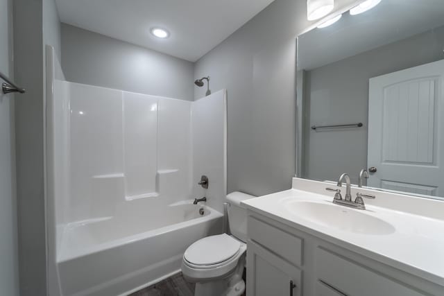 full bathroom with hardwood / wood-style floors, vanity,  shower combination, and toilet