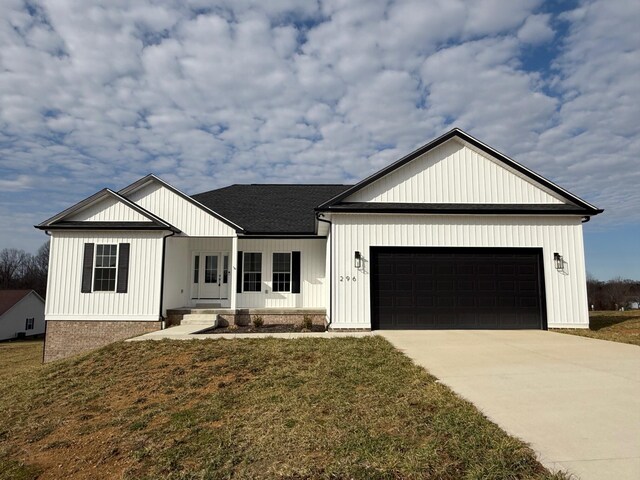 modern farmhouse featuring a garage and a front lawn