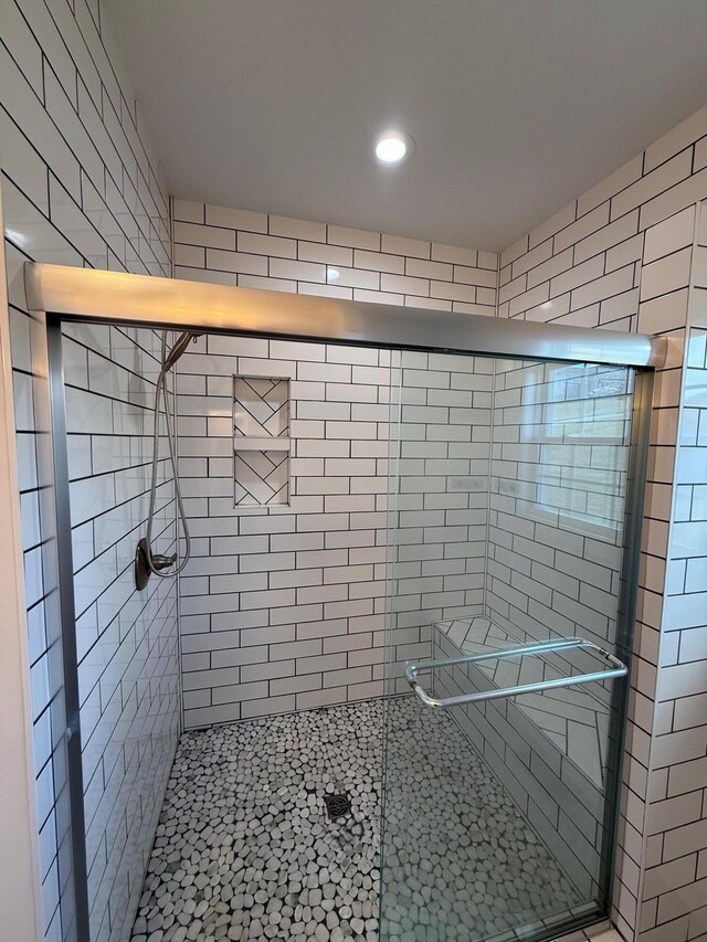 bathroom featuring a shower with shower door