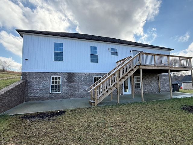 back of house with central AC unit, a deck, a patio, and a lawn