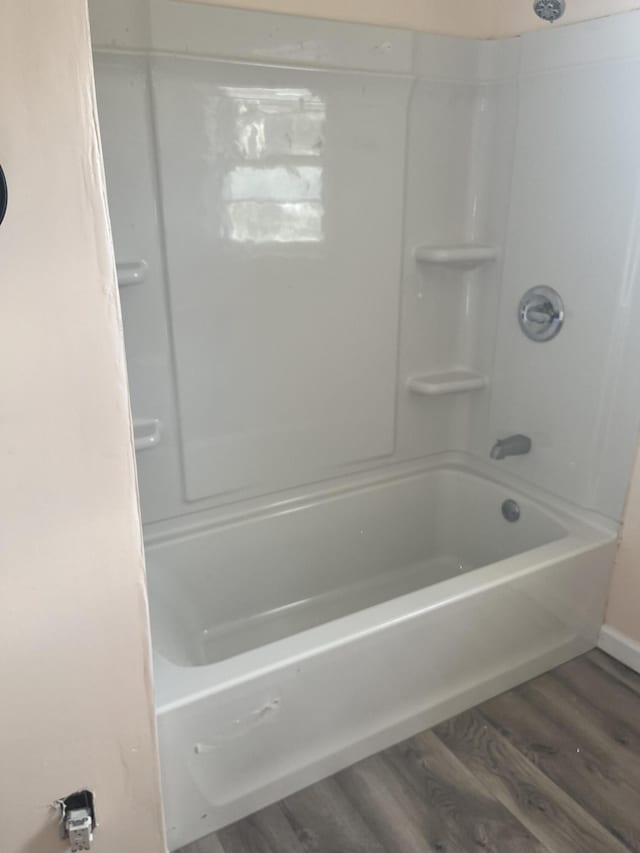 bathroom with wood-type flooring and shower / tub combination