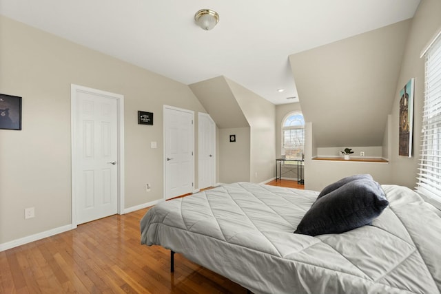 bedroom with light hardwood / wood-style flooring and lofted ceiling