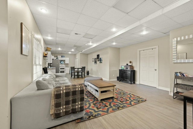 living room featuring a drop ceiling and hardwood / wood-style flooring