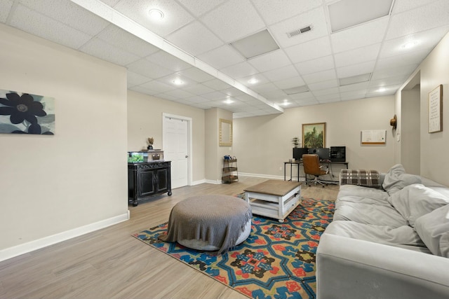 living room featuring hardwood / wood-style floors and a drop ceiling