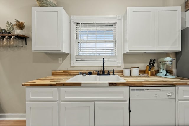 kitchen with white cabinetry, dishwasher, wooden counters, and sink