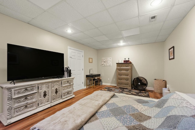 bedroom featuring a drop ceiling and wood-type flooring