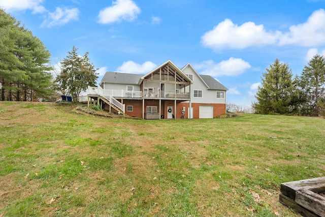 rear view of house featuring a garage, a lawn, and a wooden deck