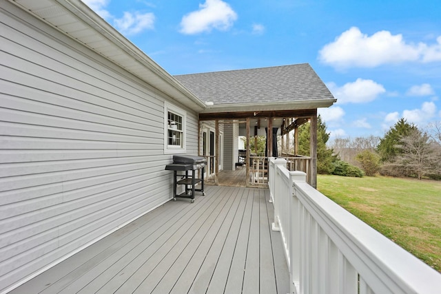 wooden terrace with a lawn and area for grilling