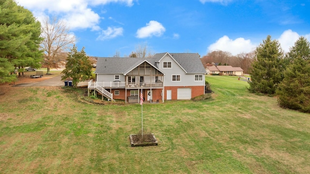 rear view of property featuring a garage, a lawn, and a wooden deck