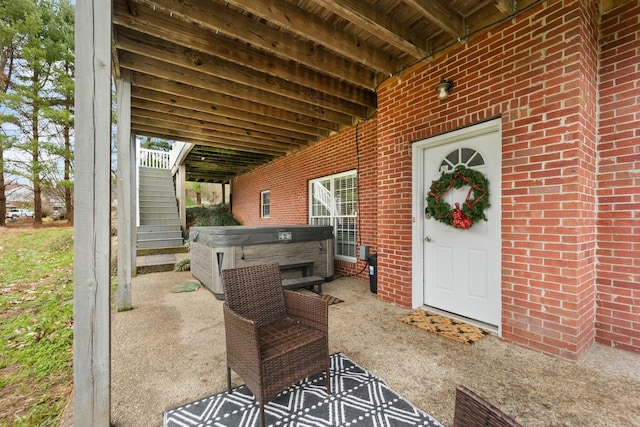 property entrance featuring a patio area and a hot tub