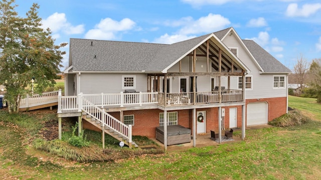 rear view of property featuring a jacuzzi, a yard, a garage, and a wooden deck