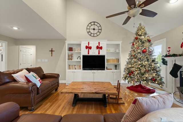 living room with ceiling fan, light hardwood / wood-style floors, and lofted ceiling