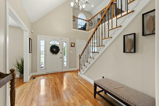 foyer entrance with a notable chandelier, a high ceiling, and light hardwood / wood-style flooring