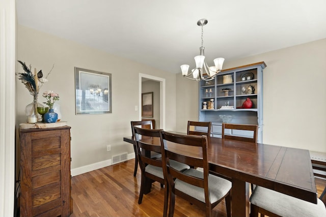 dining area with a chandelier and dark hardwood / wood-style floors