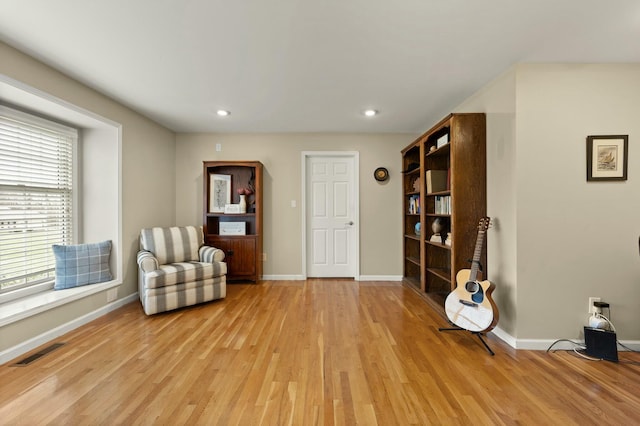 living area with light hardwood / wood-style flooring and a healthy amount of sunlight