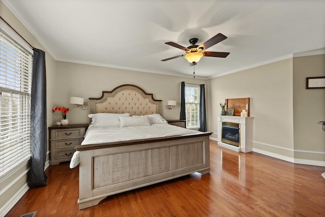 bedroom featuring ornamental molding, ceiling fan, and dark wood-type flooring