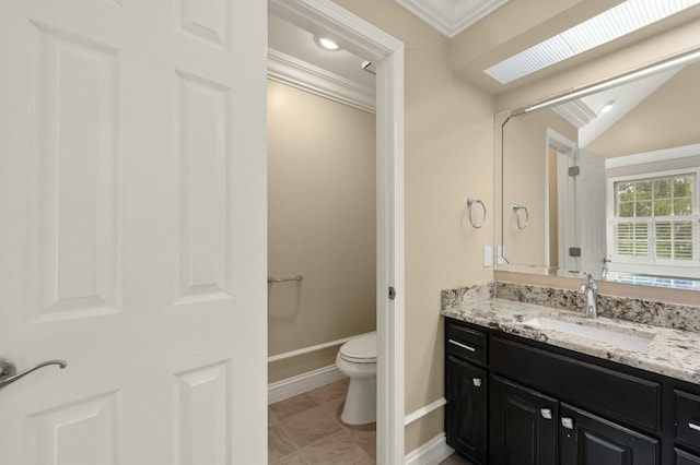 bathroom with vanity, crown molding, a skylight, tile patterned flooring, and toilet