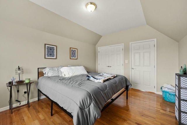 bedroom featuring lofted ceiling and hardwood / wood-style flooring