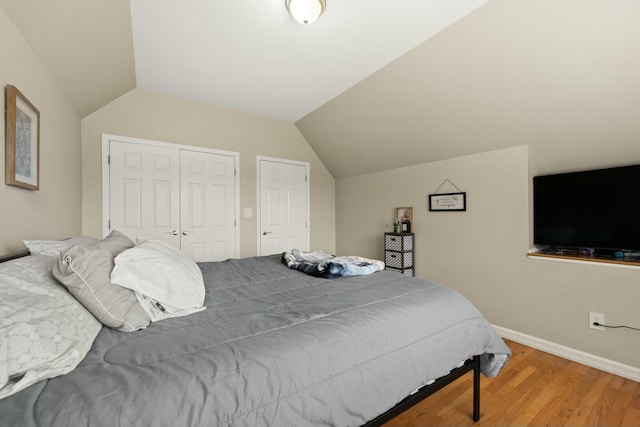 bedroom with hardwood / wood-style flooring and lofted ceiling