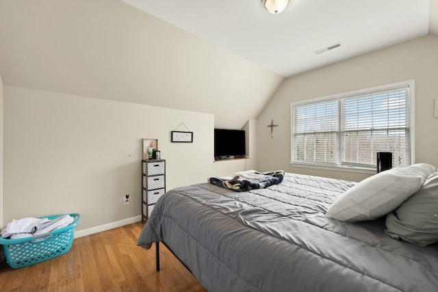 bedroom with light hardwood / wood-style flooring and lofted ceiling